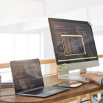Programmer working with two screens